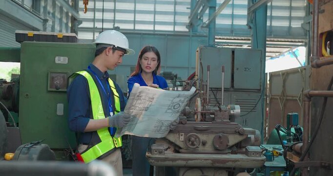 Engineer Reviews Technical Drawing With Startup Entrepreneur in Small Lab Workshop