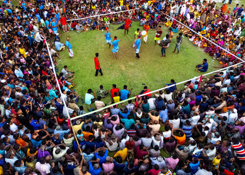 Nilphamari, Bangladesh - 01 May 2026: Aerial view of a traditional folk performance with performers and drummers in a grassy arena surrounded by a large crowd of spectators.