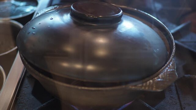 Hot Pot Simmering with Enoki Mushrooms and Tofu on a Stove
