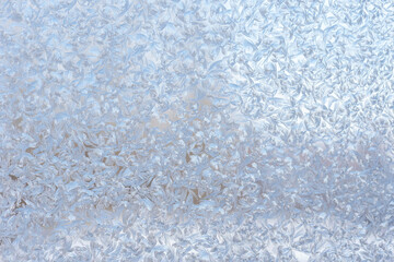 Fototapeta premium Frosted glass surface with intricate ice crystal patterns and textures reflecting light in shades of blue and silver