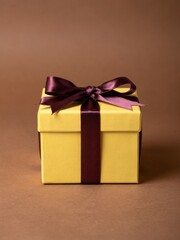 Fototapeta premium Yellow square gift box with a purple satin ribbon bow tied on top sits on a brown surface for holiday gifting, seasonal retail campaigns and festive celebrations