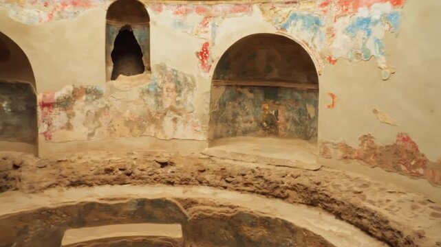 Circular Pompeii chamber with a sunken basin, arched wall niches, and faded painted plaster, suggesting an ancient bath room or water-focused interior space.