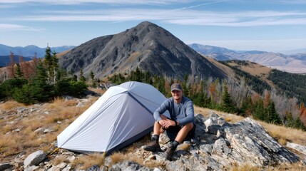 Fototapeta premium Man camping on mountain ridge with tent