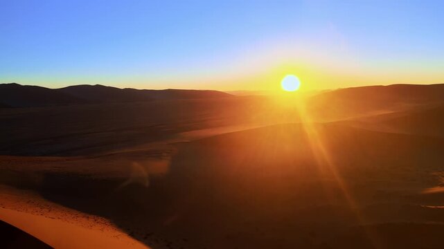 Drone footage captures the vast Namib Desert with towering red sand dunes glowing under the low setting sun, revealing breathtaking panoramic views of shifting patterns and timeless desert beauty.