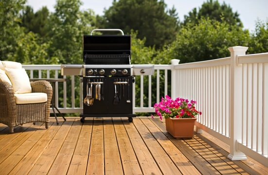 Backyard deck with gas grill and wicker chair