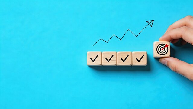 Hand holding wooden block with target icon checklist progress upward growth arrow business success goal achievement strategy planning blue background top view minimal concept