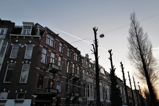 Minimalist evening sky with contrails over traditional Dutch houses in Amsterdam