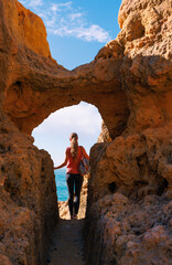 adventurous woman discovering a secret coastal passage in algar seco © M.studio
