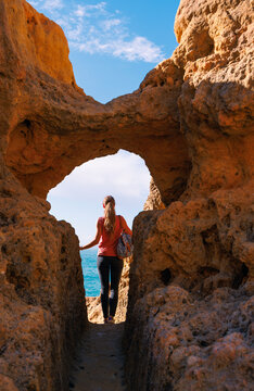 adventurous woman discovering a secret coastal passage in algar seco