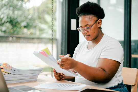 Woman working on business paperwork at home office desk