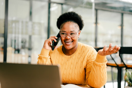 Black woman smiling while having a phone conversation