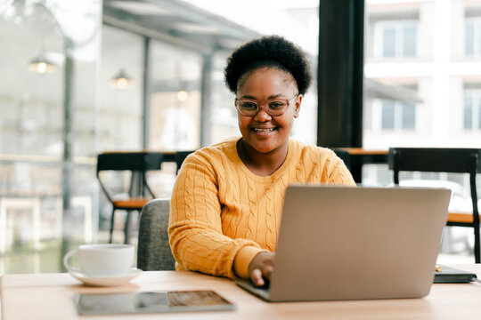 African american woman working on laptop in cafe
