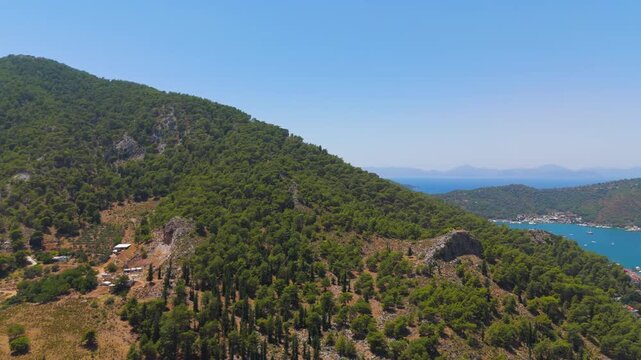 Fethiye, Turkey. Aerial view of the landscape with Fethiye Castle ruins and Turkish flag on the hill overlooking the sea and city on a sunny day.. Aerial View, MasterShots, Tilt up, Tilt down