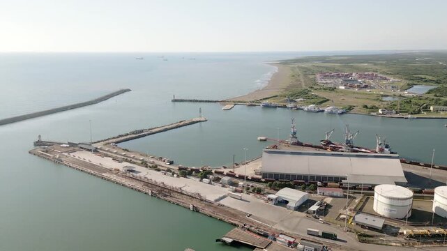 Poti, Georgia - 22nd august, 2025: aerial view Harbor basin with breakwaters, cranes, warehouse, fuel tank, rail tracks, coastline, ships offshore, Poti city seaport daylight logistics hub operations