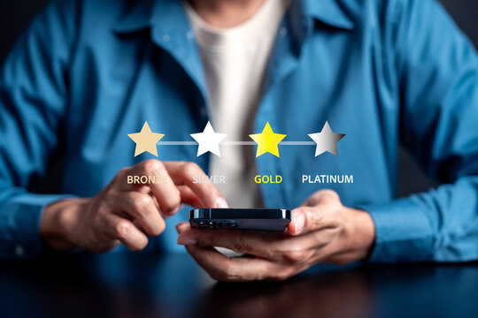 Loyalty rewards program tiers for customer membership. Man touching smartphone with bronze silver gold and platinum star for business marketing.