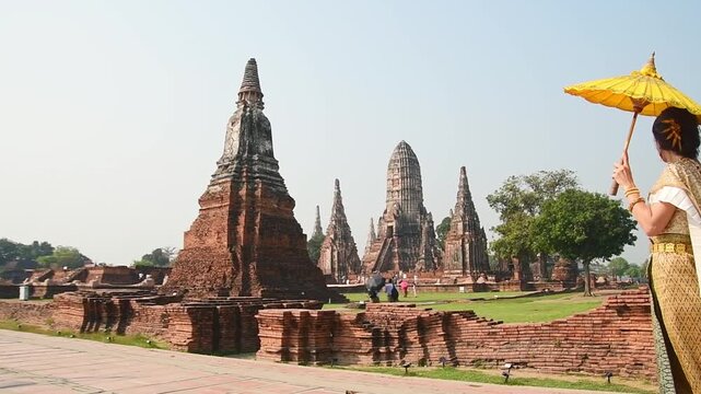 Thailand, Ayutthaya - march 15th, 2023: Woman in traditional Thai dress pose sightseeing visit ancient Buddha statue.Ayutthaya historical park. UNESCO World Heritage Site