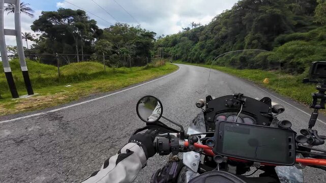 First-person point of view (POV) of a thrilling motorcycle journey along a winding mountain road, featuring lush scenery and navigation, La Colonia Tovar Road