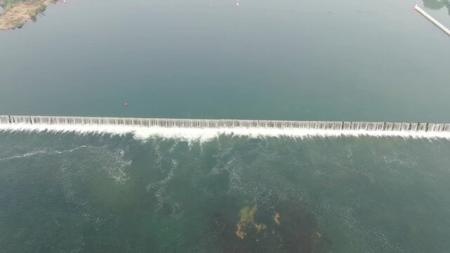 Aerial View of Waves Breaking Over a Sea Barrier