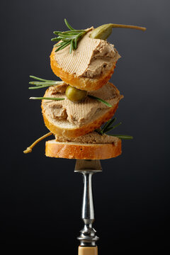 Sandwiches with liver pate garnished with rosemary and capers.