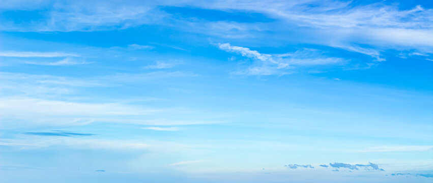 Beautiful bright blue sky with white wispy clouds on a sunny day for nature background and freedom concept with copy space