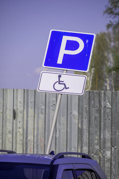 A lopsided parking sign for the disabled on a spring day