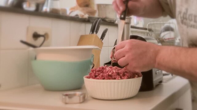 Cleaning electric meat grinder at home kitchen by washing parts and removing leftover meat