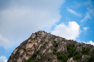 Fototapeta premium Rocks rise high in Matka Canyon near Skopje with clouds above and greenery on the slopes