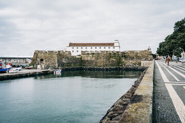 Fototapeta premium Historic seaside fortress and promenade under cloudy sky