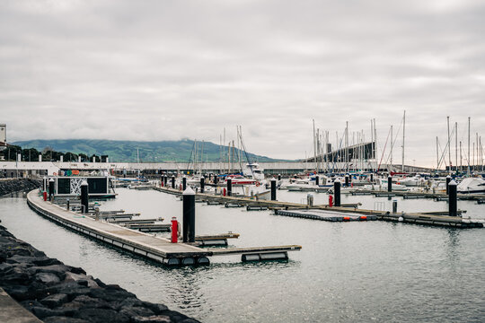 Ponta delgada marina with boats and mountains in azores