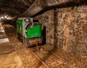Fototapeta premium Abandoned mine tunnel with rails and mining cart