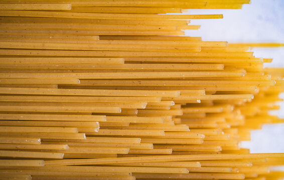 Close up of dry uncooked spaghetti noodles filling frame.