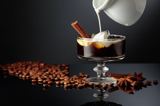 Cream is poured into a glass with coffee liquor and ice.