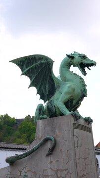 Dragon statue detail shows the iconic Dragon Bridge landmark in Ljubljana, Slovenia, vertical close up shot.