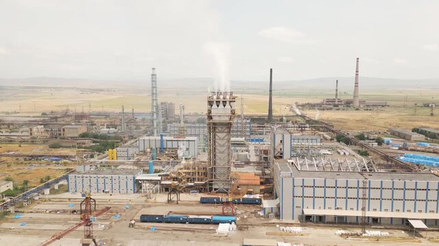 Aerial view of Rustavi Azot chemical factory with smokestacks, overgrown wasteland, and polluted surroundings showing industrial production and environmental damage in Georgia