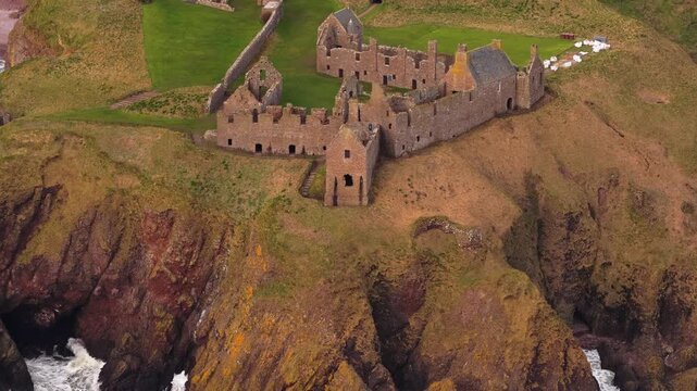 Beautiful aerial footage flying over the dramatic ruins of dunnottar castle, a medieval fortress perched on a rocky headland near stonehaven