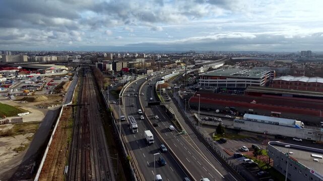 Heavy traffic on Boulevard P&eacute;riph&eacute;rique, ring road highway surrounding Paris, next to railway lines, France. Aerial forward