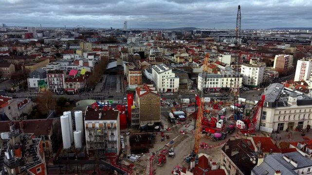 Large urban construction site surrounded by cityscape of Paris, France. Aerial drone panoramic view