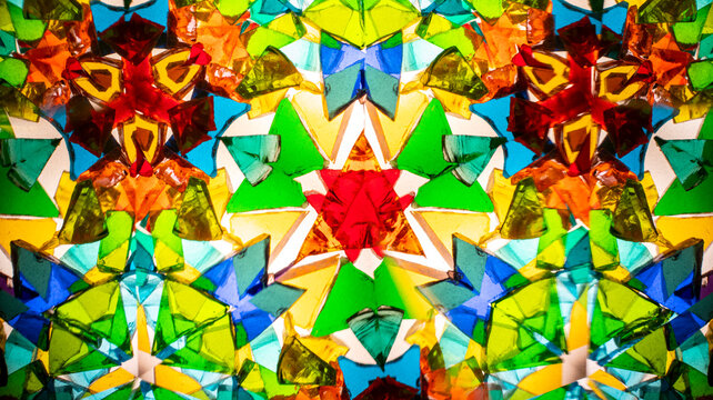 Macro photo of a real kaleidoscope pattern shot on camera. Centered design with red, blue, green, and orange. Ideal for abstract backgrounds, 3D texturing, web design, and decorative prints.