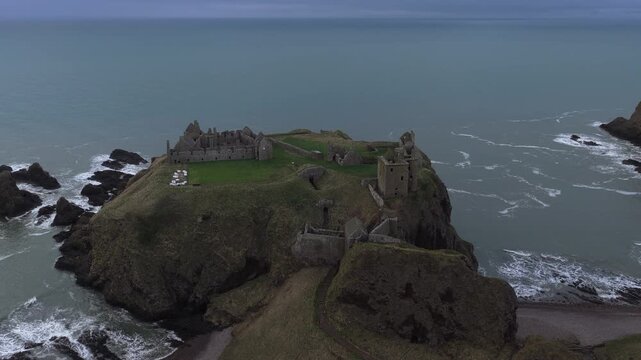 Dramatic aerial footage of the historic dunnottar castle, a ruined medieval fortress situated on a rocky headland on the northeastern coast of scotland