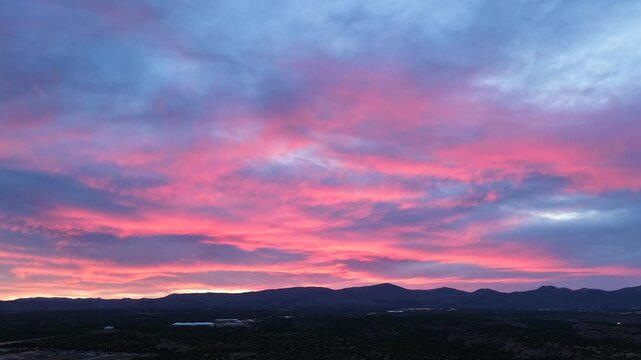 A cinematic 4K drone timelapse captures the final sunset colors bursting from the sky. This dramatic transition from dusk to twilight creates an evocative nature background for B-roll.