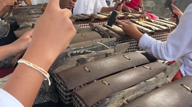 Close up of musicians playing Selonding Balinese Gamelan traditional percussion instrument in Bali, Indonesia