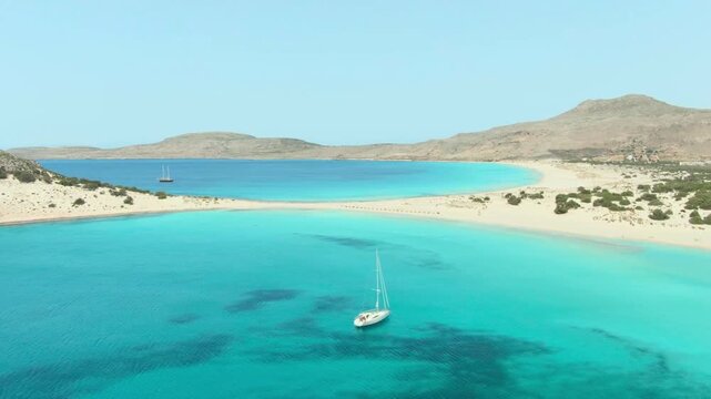 Tropical Mediterranean landscape featuring a white yacht in a crystal clear blue sea with sandy beaches and mountains.
