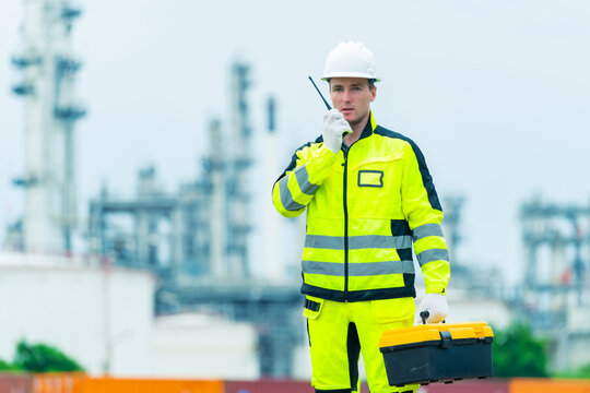 Railway engineer inspecting railroad track with laptop and radio communication device during railway maintenance operation, industrial transportation infrastructure worker checking rail system