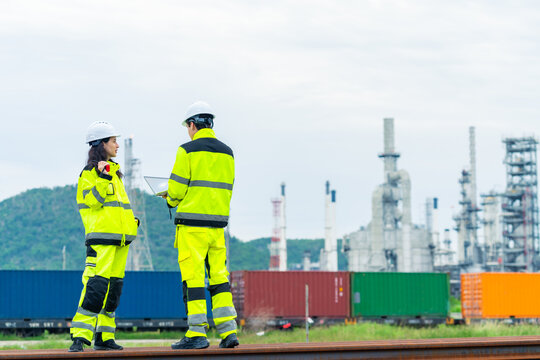 Petroleum refinery engineers and industrial worker working on laptop, inspection oil refinery plant at construction site with radio communication, technician teamwork maintaining energy power system