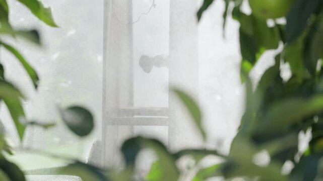 Close-up of sprayer nozzles working in an apple orchard, agricultural machine spraying plant protection product among green trees