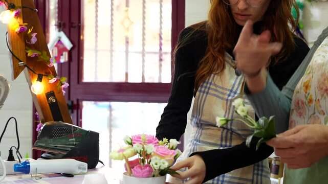 Two artisans creating a beautiful floral arrangement with soap flowers during a creative workshop