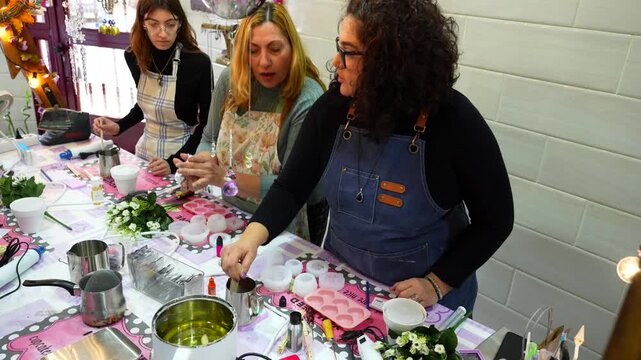 Group of women learning the craft of making handmade candles during a creative master class