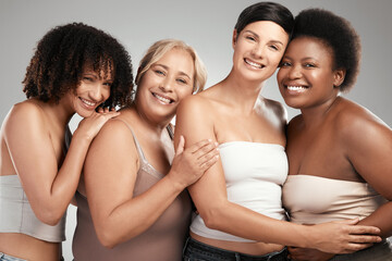 Fototapeta premium Diversity, portrait and women with hug in studio for skincare or dermatology on a white background. Multiracial, female people or group of friends with smile or embrace for beauty, love or inclusion