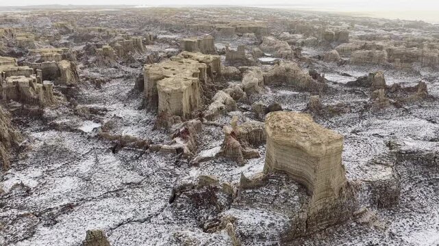 Aerial view of the Danakil Desert showing unique salt pillars and volcanic formations across the desolate landscape in Dalol, Afar, Ethiopia.