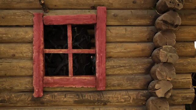 Traditional log cabin wall with rustic red window frame and wooden texture